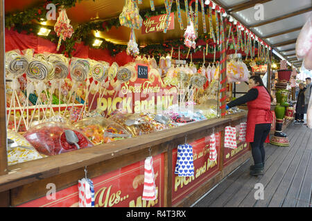 Signora disponendo di merci su toffee stallo, al Winter Wonderland, Nottingham, Inghilterra. Foto Stock