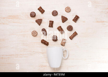 Un bicchiere di latte al cioccolato e la varietà di cioccolatini sul tavolo Foto Stock