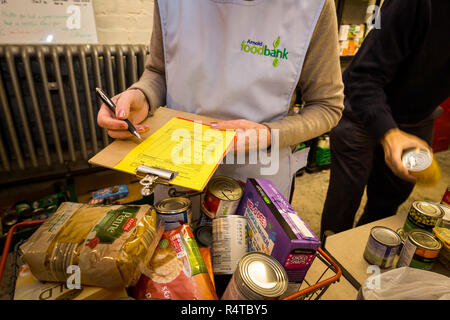 Volontari risolvere il neo arrivato donazioni a Arnold Foodbank Daybrook chiesa battista il negozio di alimentari e fornire a chi è nel bisogno con cibo donato a Nottingham. Foto Stock