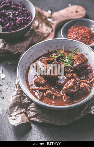 Delizioso gulasch con cavolo rosso peperoncino e rosmarino Foto Stock