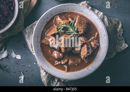 Delizioso gulasch con cavolo rosso peperoncino e rosmarino Foto Stock