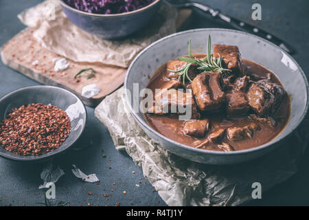 Delizioso gulasch con cavolo rosso peperoncino e rosmarino Foto Stock