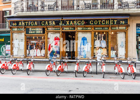 Barcellona, Spagna - 4 Ottobre 2017: Biciclette parcheggiate fuori negozio di abbigliamento su Las Ramblas. La strada è molto famosa zona pedonale dello shopping e. Foto Stock