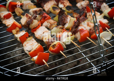 Spiedini spiedini di carne, i peperoni e le cipolle su un barbecue grill, selezionata la messa a fuoco e profondità di campo ridotta Foto Stock