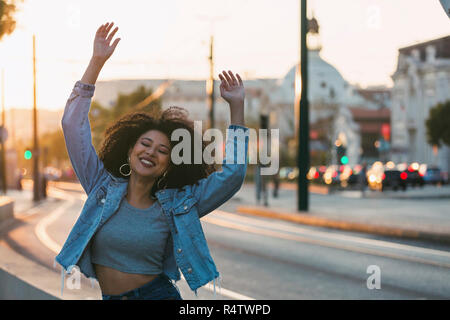 Ritratto di spensierata esuberante giovane donna sulla strada urbana, Lisbona, Portogallo Foto Stock