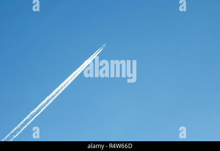 Traccia di un aereo contro il cielo blu Foto Stock