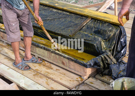 Lavoratore presso un cantiere a casa copre le schede antisettico. Impregnazione di schede madri. Foto Stock