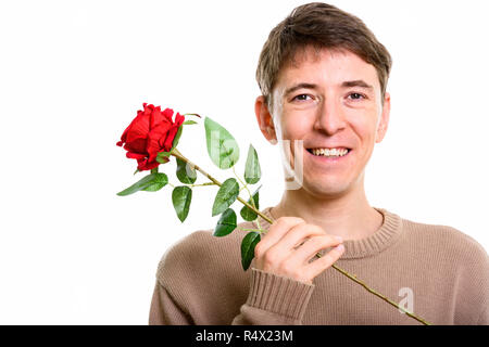 Close up di felice uomo sorridente mentre si tiene una rosa rossa Foto Stock