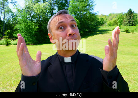 Guardare un buon sacerdote cattolico è pregando nel suo giardino. Egli guarda noi con serenità, di ottimismo, di gioia e di ammirazione, la fiducia, la fiducia e la pace. Foto Stock