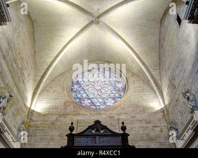 I principali fatti di pietra rosone con una vetrata decorazione e spie sotto gli archi a sesto acuto nella cattedrale di Saint Mary a Valencia, Spagna Foto Stock