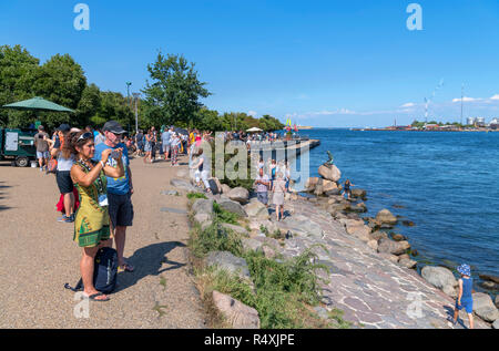 I turisti alla Sirenetta (Den lille havfrue), una statua da Edvard Eriksen, Langelinie promenade, Copenhagen, Danimarca Foto Stock