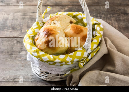 Pasqua tradizionale hot cross panini in un cestino sul tavolo di legno Foto Stock