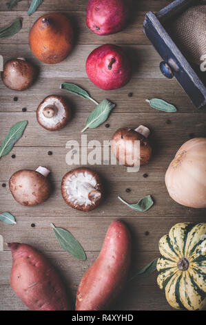 Una scena di autunno produrre come le pere, squash, patate dolci e salvia su uno sfondo di legno. Foto Stock