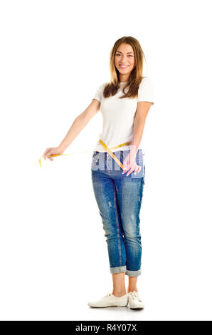Ragazza giovane misurando la sua vita isolata su uno sfondo bianco Foto Stock