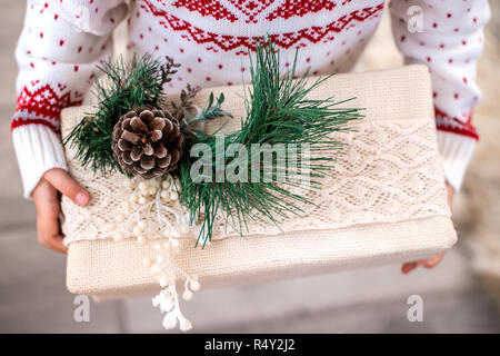 Regalo di natale Scatola in bambino con le mani in mano. Close-up. Foto Stock