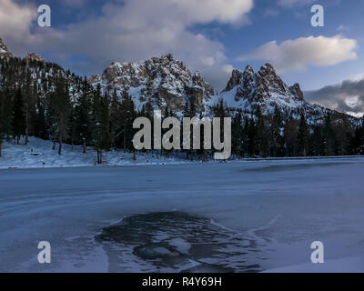 Lago alpino congelato e il paesaggio di montagna al crepuscolo, i Cadini montagne, Italia Foto Stock