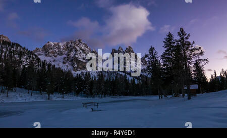 Bella scena notturna in montagna innevata valle e lago ghiacciato nelle Alpi europee Foto Stock