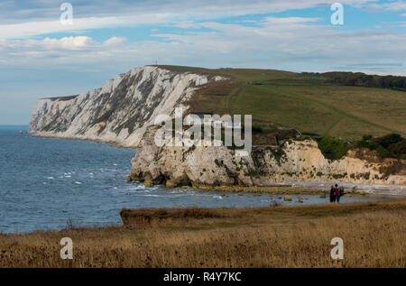 Due escursionisti che affaccia sulla baia di acqua dolce nell'isola di Wight sulla via costiera con scogliere e spiaggia. Foto Stock