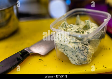 L'aneto mescolato con burro in un contenitore in plastica con lama oltre ad esso - Set da cucina Foto Stock