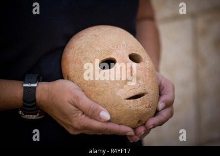 Gerusalemme, Rockefeller Museum di Gerusalemme. 28 Nov, 2018. Ronit Lupu, un archeologo dall'Autorità di Antichità Israele (IAA) detiene una maschera di pietra al Rockefeller Museum di Gerusalemme a nov. 28, 2018. Una rara pre-storica maschera in pietra risalente al Neolitico Pre-Pottery B (PPNB) periodo 9.000 anni fa, fu scoperto nel sud della Cisgiordania, l'Autorità di Antichità Israele ha detto Mercoledì. Credito: JINI/Xinhua/Alamy Live News Foto Stock