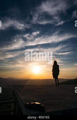 Una giovane ragazza si erge sul ponte di osservazione e si ammira lo splendido paesaggio. Foto Stock