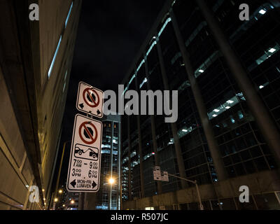 Tipico del Nord American packing e parcheggio non segni con le istruzioni dettagliate sul regolamento di parcheggio scattata di notte nel CBD di Ottawa, Ontario, Canada Foto Stock