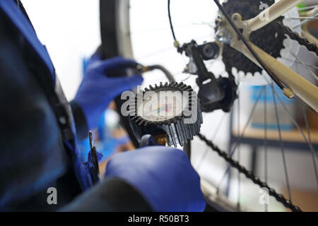 Il pompaggio della ruota di bicicletta. pompaggio del moto. il meccanico in bike service pompata la ruota di bicicletta con un compressore aria. Foto Stock