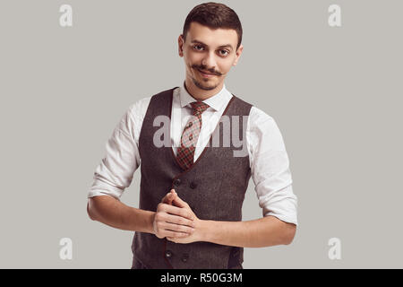 Ritratto di bel giovane fiducioso arabo imprenditore con baffi di fantasia in lana abito marrone su sfondo per studio Foto Stock