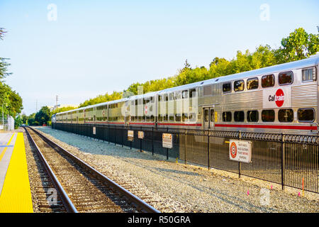 Agosto 21, 2018 Palo Alto / CA / STATI UNITI D'AMERICA - Caltrain (treno locale passando attraverso la Silicon Valley) lasciando una stazione del sud di San Francisco Bay Area Foto Stock