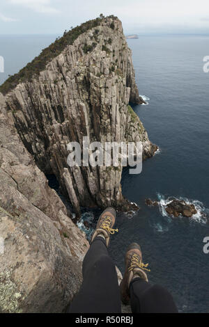 Appendere i piedi dalla scogliera, Cape Hauy, Tasmania, Australia Foto Stock