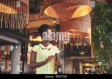 African American Business donna stand con una cartella nelle sue mani Foto Stock