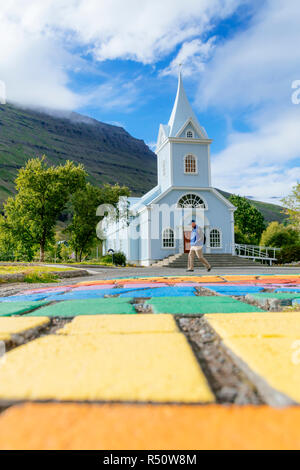 La strada pedonale principale di Seyðisfjörður Affitto è dipinto in luminosi colori dell'arcobaleno, Islanda Foto Stock