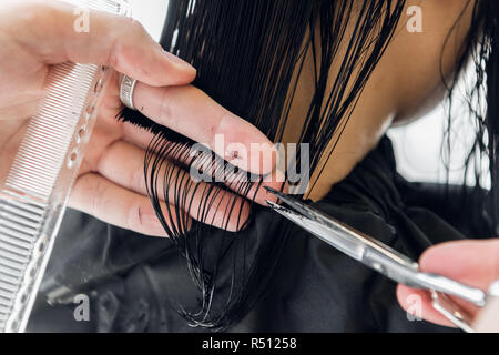 Parrucchiere taglia i capelli di una donna. Close-up. Foto Stock