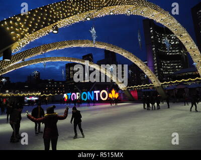 Pista di pattinaggio con luci di Natale di lit e segno di Toronto, serata davanti a Toronto il moderno City Hall Foto Stock