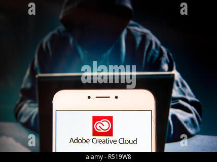 File del servizio di hosting e il computer accesso al software di proprietà di Adobe Systems Adobe Creative Cloud, il logo è visibile su un androide dispositivo mobile con una figura di hacker in background. Foto Stock