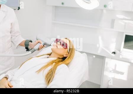 Donna getting laser e la faccia di ultrasuoni nel trattamento medico del centro termale Foto Stock