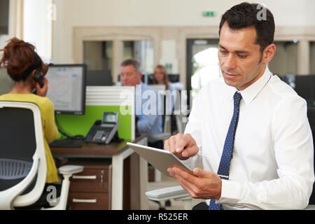 Imprenditore utilizzando digitale compressa in un ufficio moderno Foto Stock
