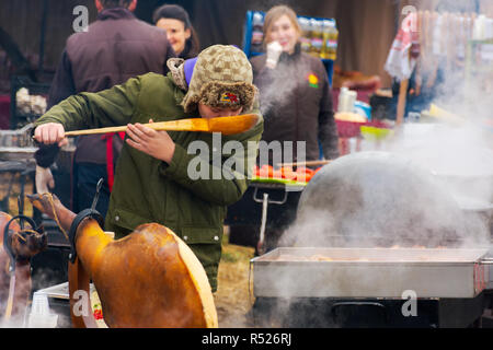 Hecha, Ucraina - Jan 27, 2018: norcineria concorrenza. calderone bollente sul fuoco. spalla di suino sul tavolo. il capretto con grosso cucchiaio piatti degustazione Foto Stock