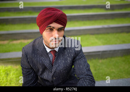 Commerciante indiano con turbante seduti all'aperto in città Foto Stock