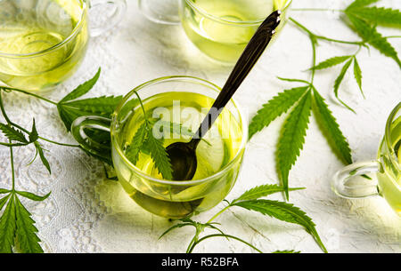 La Cannabis tè alle erbe serviti in vetro teacups con foglie di marijuana Foto Stock