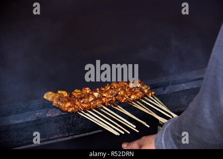 Pollo Satay è bruciato dal venditore. Bandung. Indonesia. Foto Stock