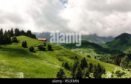 Una piccola fattoria edificio sorge sul fianco di una collina che si affaccia sulla valle in cima al Col de l'Arpettaz in Annecy, Francia il 14 giugno 2018. Foto Stock