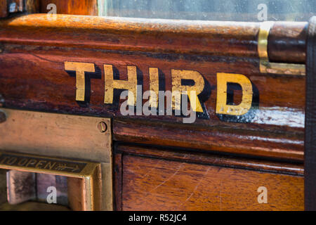 La terza parola dipinta in oro / lettere scritte sulla porta passeggero / porte passeggeri di un vecchio vintage treno a vapore carrello. England Regno Unito. (98) Foto Stock