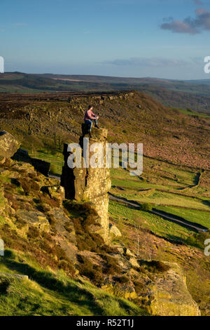 Persona seduta in cima al Pinnacle Rock Peak District Derbyshire England Foto Stock
