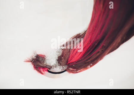 Parrucchiere tingere i capelli di colore rosso in un salone di bellezza. Foto Stock