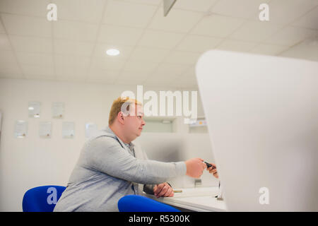 Giovane uomo dando auto della chiave per il suo cliente nel suo ufficio. Il concetto di business. Foto Stock