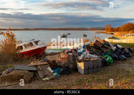 Fotografia paesaggio di gran mucchio di rifiuti raccolti e rifiuti raccolti da volontari con il porto di Poole in background. Foto Stock