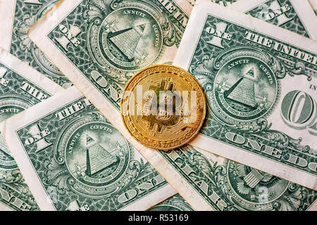 Soldi virtuali golden bitcoin su un dollaro dello sfondo. Concetto di nuovo ordine mondiale di cryptocurrency. Exchange bitcoin in contanti per un dollaro. Foto Stock