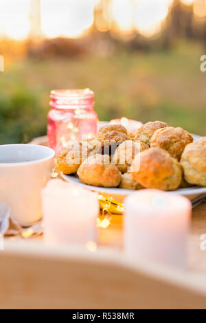 Deliziosi biscotti con candele su un vassoio in legno all'esterno Foto Stock