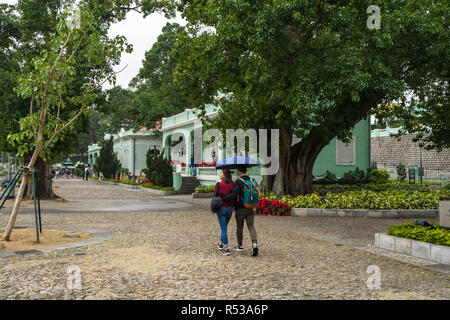 Una giovane coppia passeggiando nella parte anteriore di Taipa Houses-Museum, un complesso museale di cinque tradizionali case portoghese. Macao, Gennaio 2018 Foto Stock